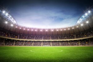 Estádio de futebol com arquibancadas vazias e campo verde, simbolizando a paixão pelo esporte.