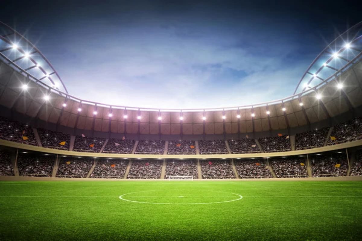 Estádio de futebol com arquibancadas vazias e campo verde, simbolizando a paixão pelo esporte.